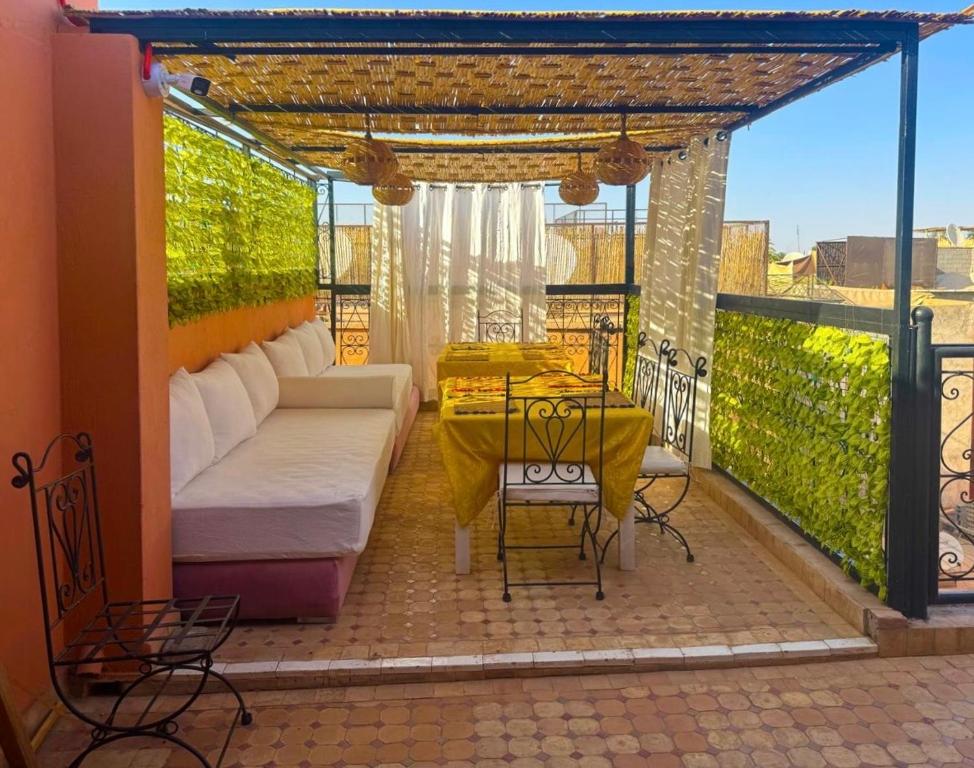 a patio with a couch and a table on a balcony at Riad Le Bijou de Zahra Marrakech Kasbah in Marrakech