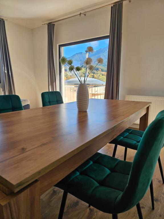 ブランにあるPanoramic Chalet Branのダイニングルームテーブル(緑の椅子、花瓶付)