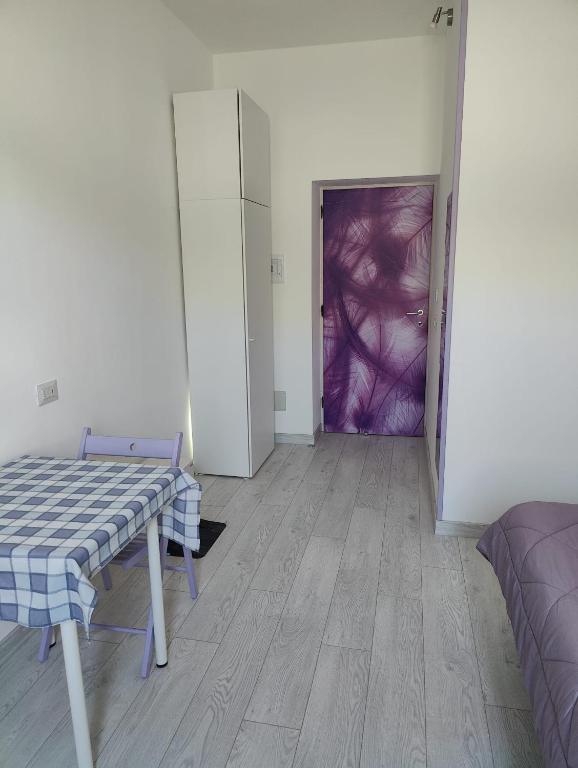 a room with a table and a door with a purple wall at La Rosa di Orvieto in Orvieto