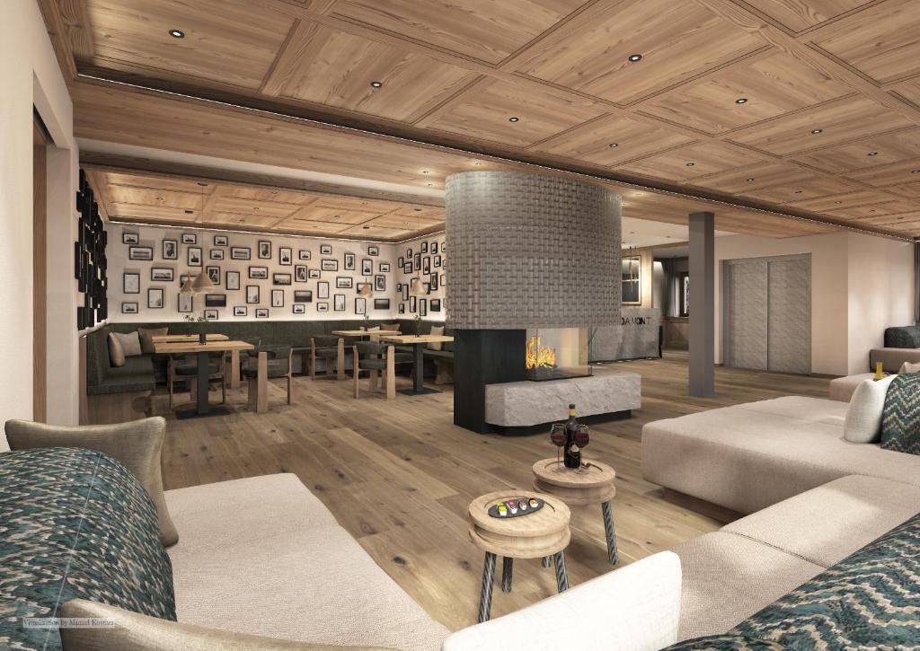 a living room with a couch and a fireplace at Hotel Fil Da Mont in Selva di Val Gardena