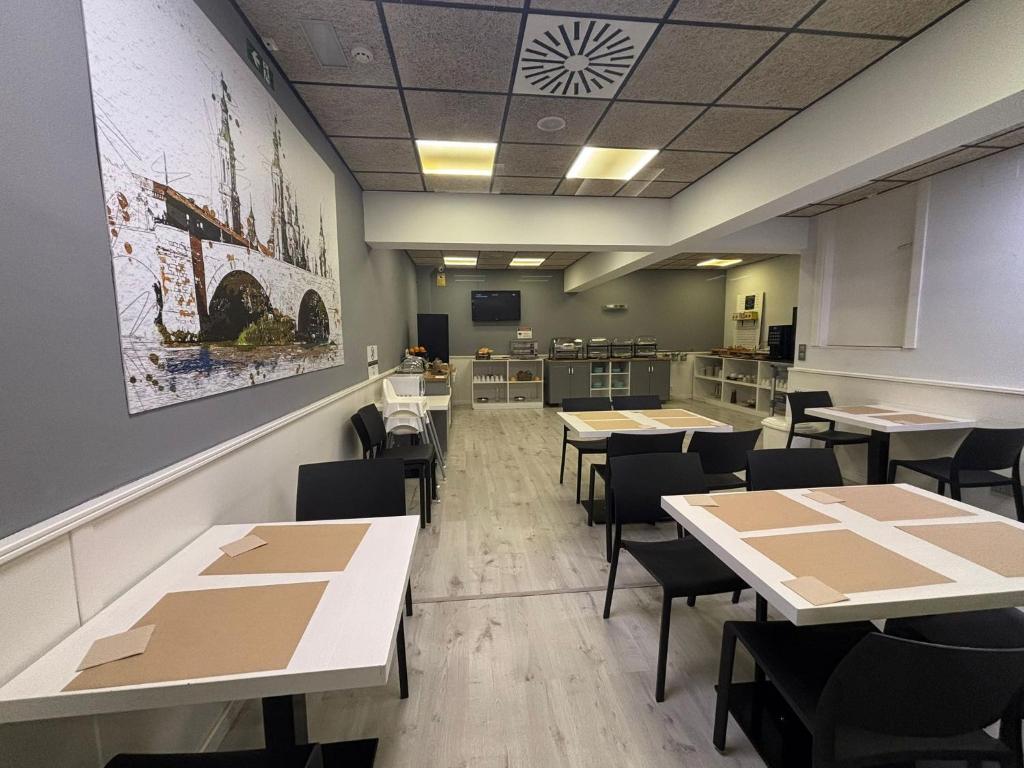 Un comedor vacío con mesas y sillas. en VTZ Hotel Plaza España, en Zaragoza