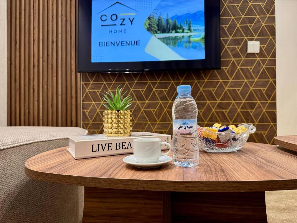 a coffee table with a bottle of water and a drink at Comfort & Style Apartment in Kenitra