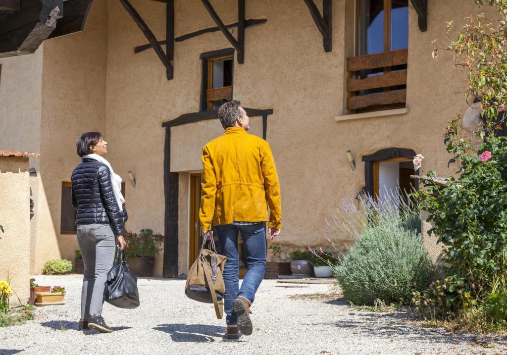 GillonnayPlaine et Colline Chambres et table d'hôtes Isère的走过建筑物的男人和女人