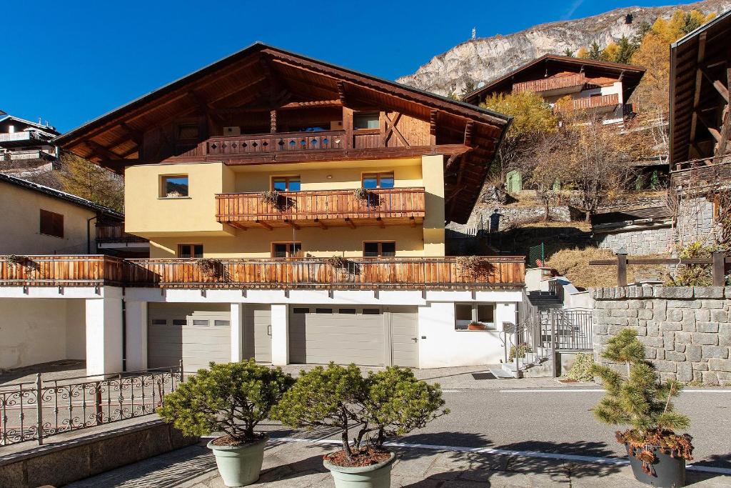 ein Wohnhaus mit Balkon und Bäumen davor in der Unterkunft Appartamenti Via Dell'Asilo in Isolaccia