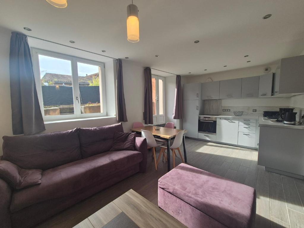 un soggiorno con un divano e un tavolo di Charmant 2 pièces avec jardin - Hyper centre BSM a Bourg-Saint-Maurice