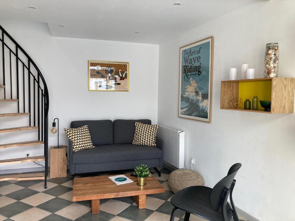 a living room with a couch and a table at Charmante maison à 200m de la plage in Hossegor