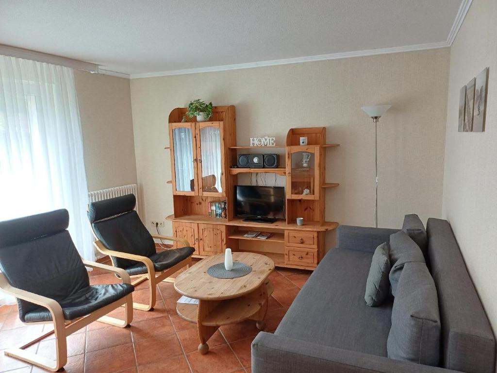 ein Wohnzimmer mit Sofa, Sesseln und Fernseher in der Unterkunft Moderne Ferienwohnung in Pudagla mit Grill, Garten und Terrasse in Pudagla