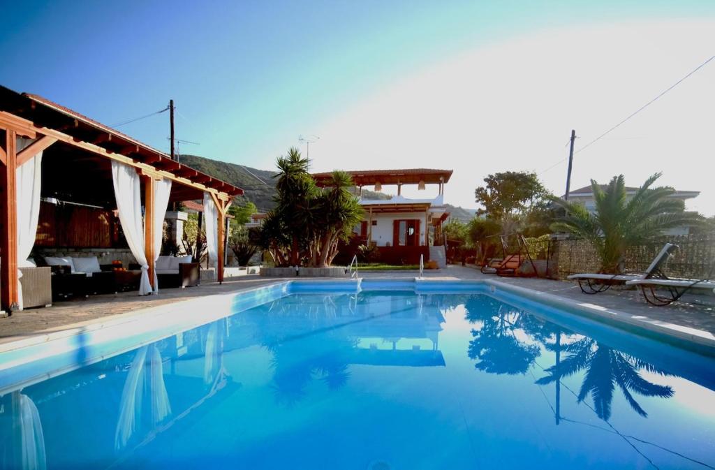 a large blue swimming pool in front of a house at Cittadella Asprovalta 3BR - private pool in Asprovalta