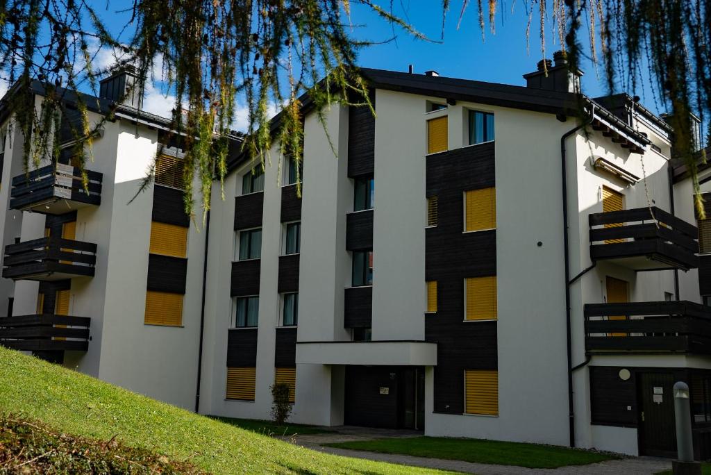 an apartment building with yellow and black windows at Casa Laret 6-12 in Laax-Murschetg