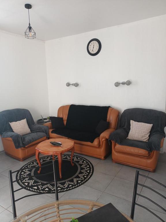 a living room with two couches and a table at Appartement meublé avec deux chambres in Moulins