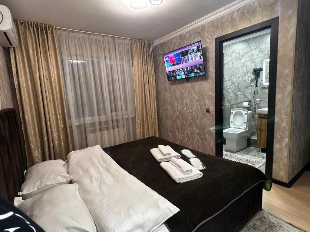 a hotel room with a bed with towels on it at Hotel LION Almaty in Almaty