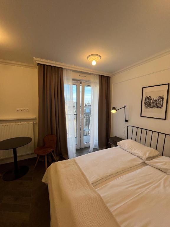 Cozy and quiet apartment in the city centre في بوزنان: غرفة فندقية بسرير وطاولة ونافذة