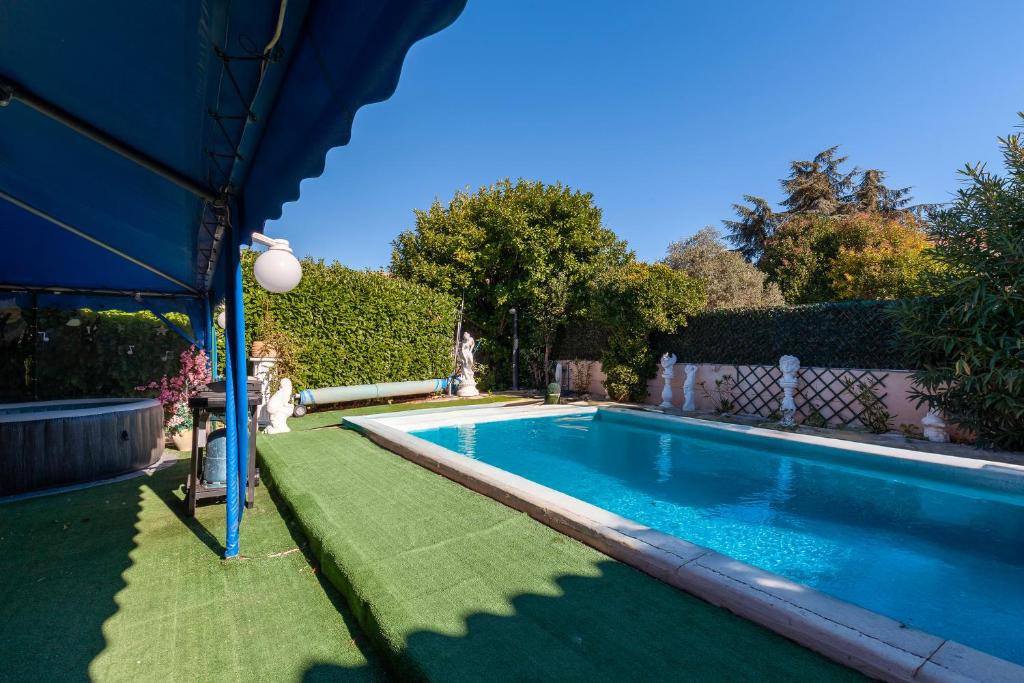 a swimming pool with a green lawn around it at Villa Soleil Et Douceur in La Seyne-sur-Mer