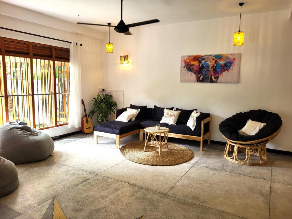 a living room with a couch and a table at Kalavida - 2 Mins walk to Kabalana Beach in Piyadigama