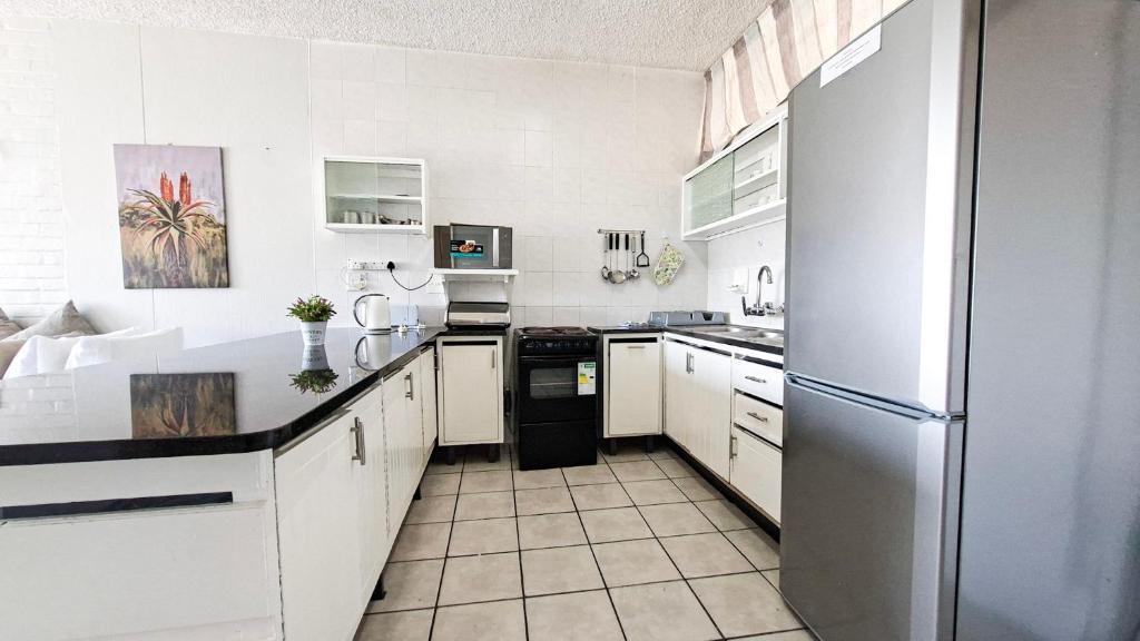 eine Küche mit weißen Schränken und einem Edelstahlkühlschrank in der Unterkunft Seagull 204 in Margate