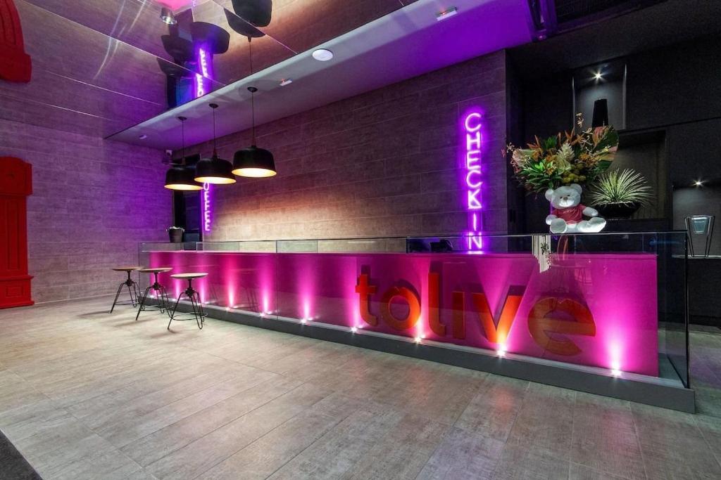 a bar with purple lights and a sign that reads novation at Tolive One - Ilha do Leite, Recife in Recife