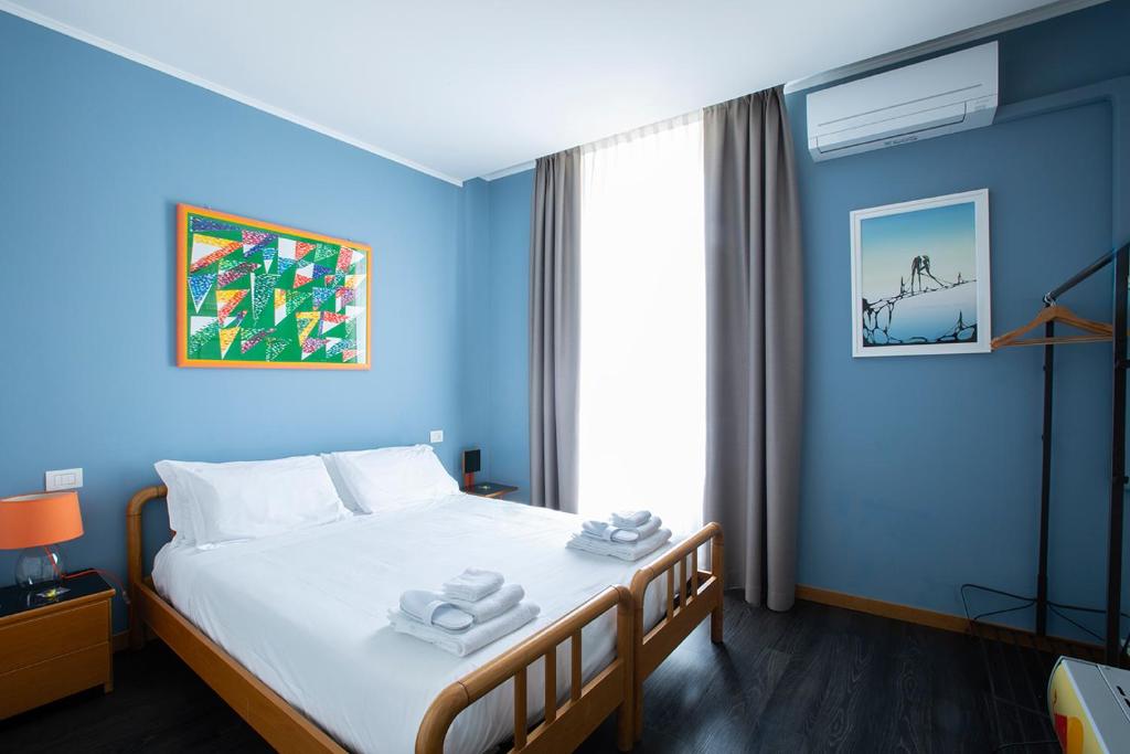 a blue bedroom with a bed with towels on it at Albergo Giardino in Cernobbio