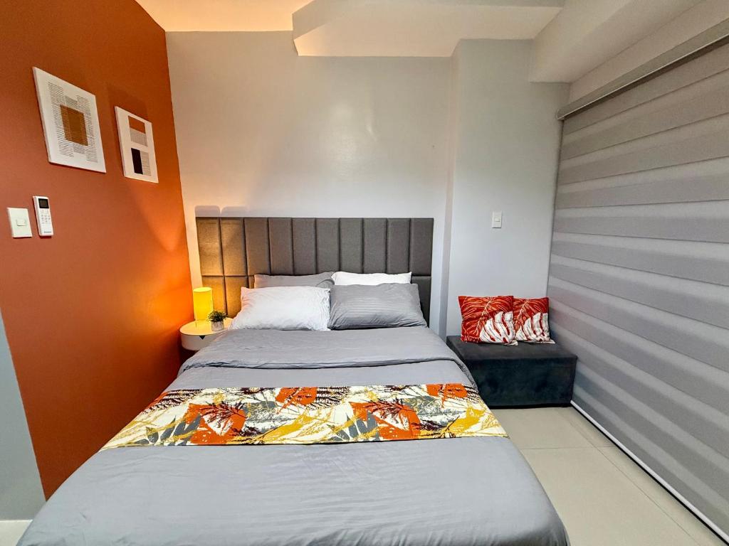 a small bedroom with a bed and orange walls at RGM PLACE in Davao City