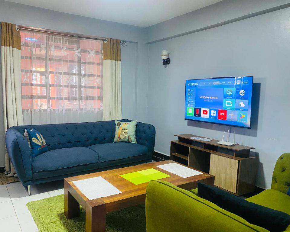 ナイバシャにあるPendeza homesの青いソファとテレビのあるリビングルーム