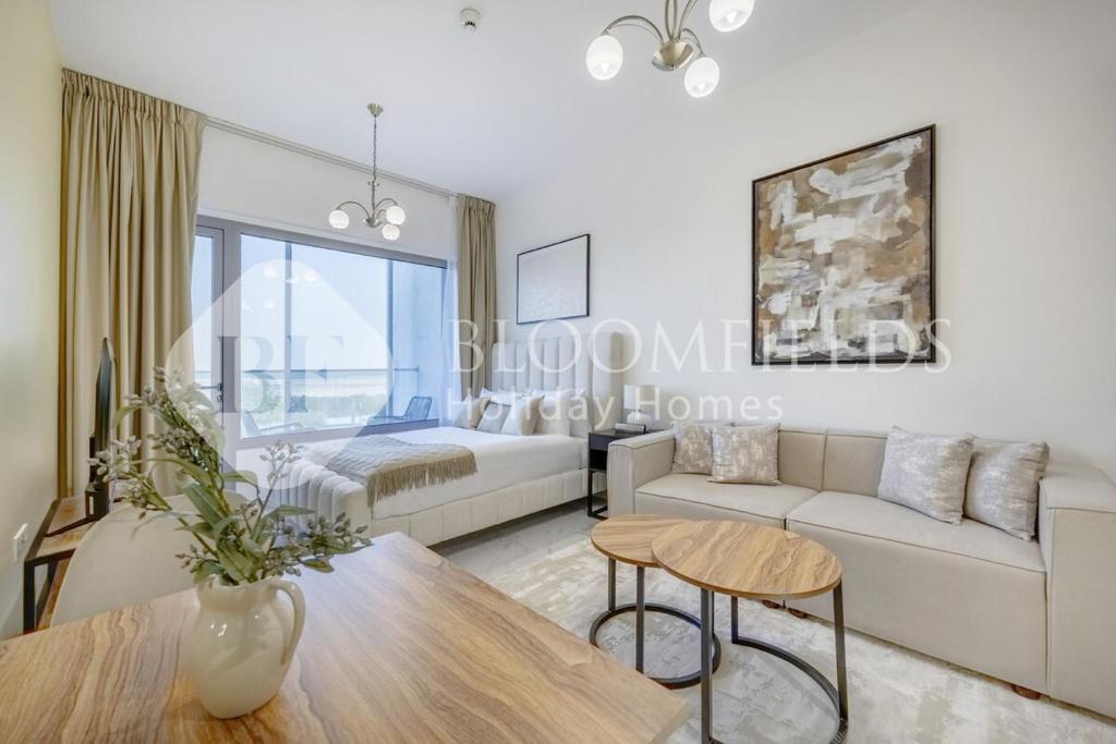 una sala de estar con un sofá y una mesa en Bloomfields Snug Stu Oasis Masdar, en Al Wathbah