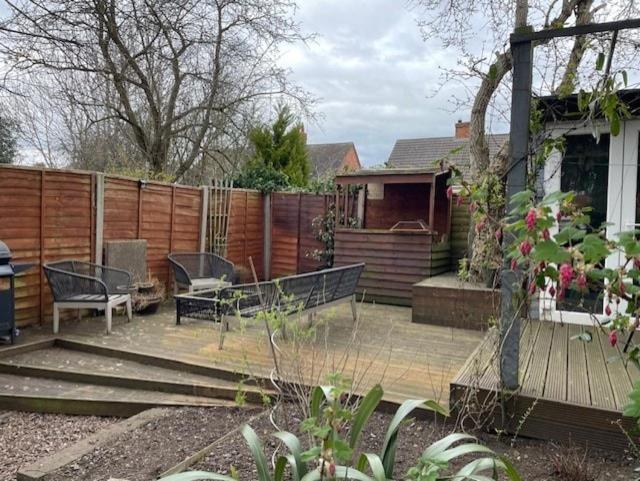 a backyard with two benches and a fence at Cosy 3-bed Terrace Home, Nantwich in Nantwich