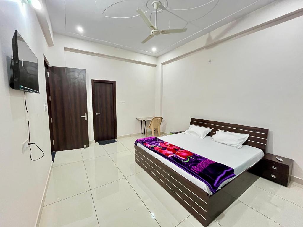 a bedroom with a bed and a flat screen tv at HOTEL GLORY IN Chatha meel,raitha road lucknow in Bhauli