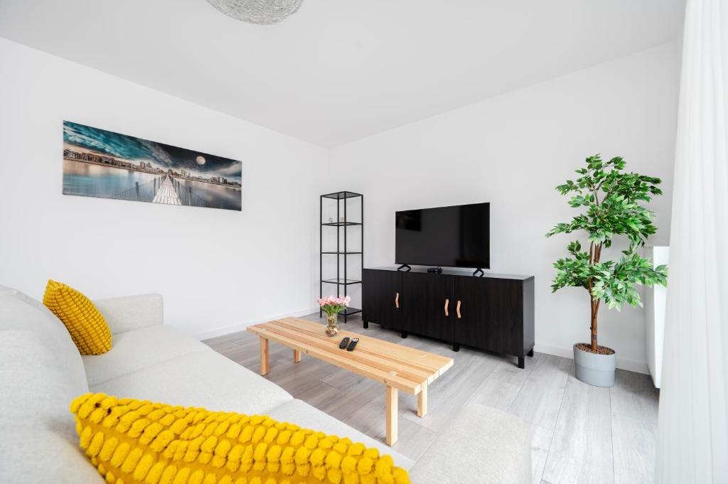 un soggiorno bianco con un divano e una TV di Widzewska Prime Apartments by BookingHost a Łódź