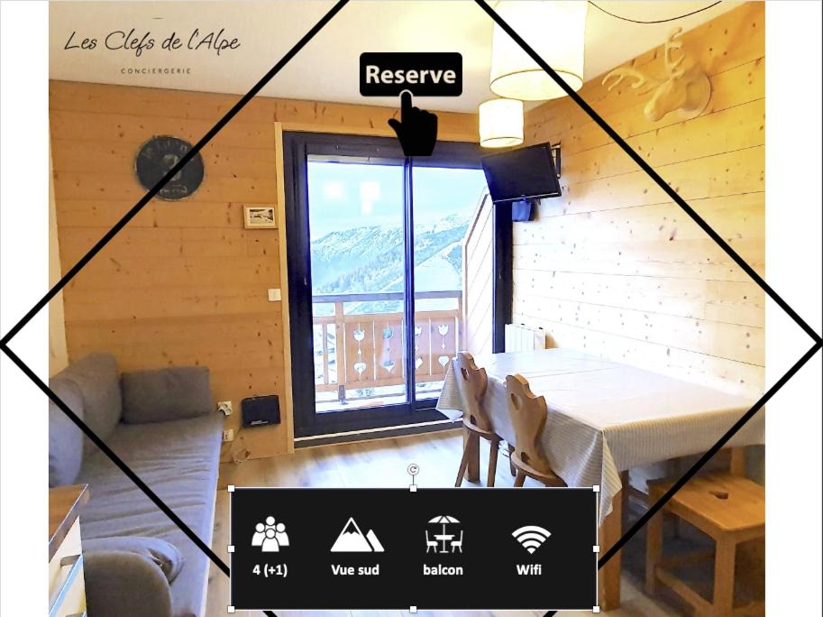 a living room with a table and a large window at Près des pistes - Plein sud - Vue incroyable in LʼHuez