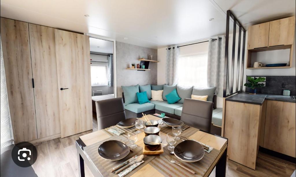 a living room with a table and a couch at Camping les dunes de contis in Saint-Julien-en-Born