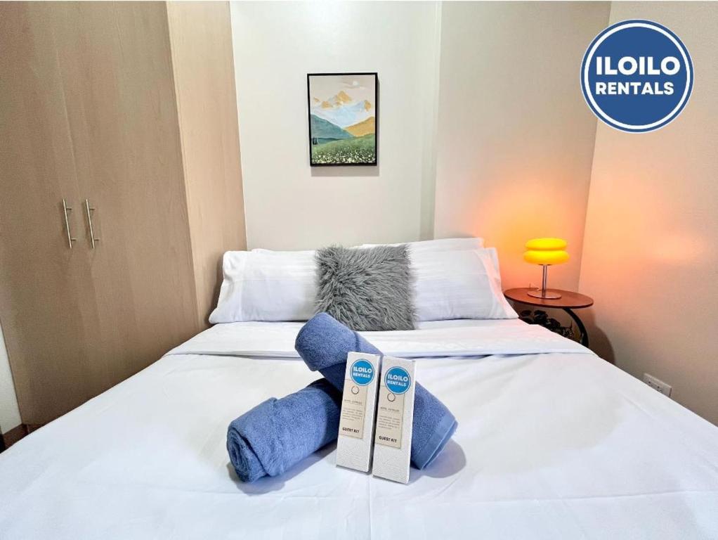 a white bed with two pillows on top of it at Live in style Studio at Saint Dominique in Mandurriao