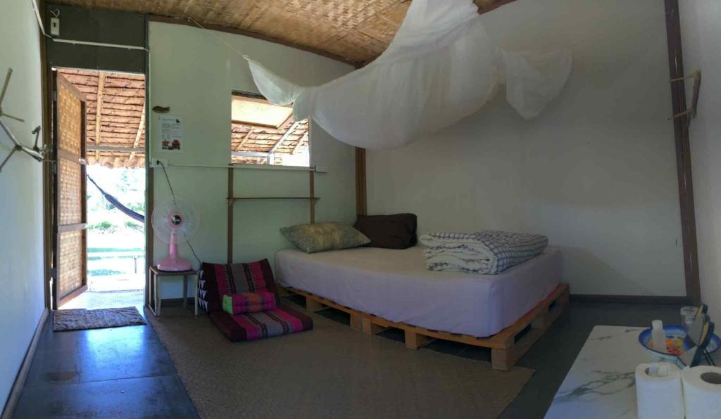 a bedroom with a bed and a window at Sparrow Hut in Pai