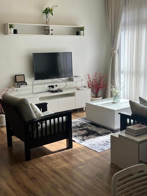 a living room with a tv and a couch at The Happy Nest in Kampala