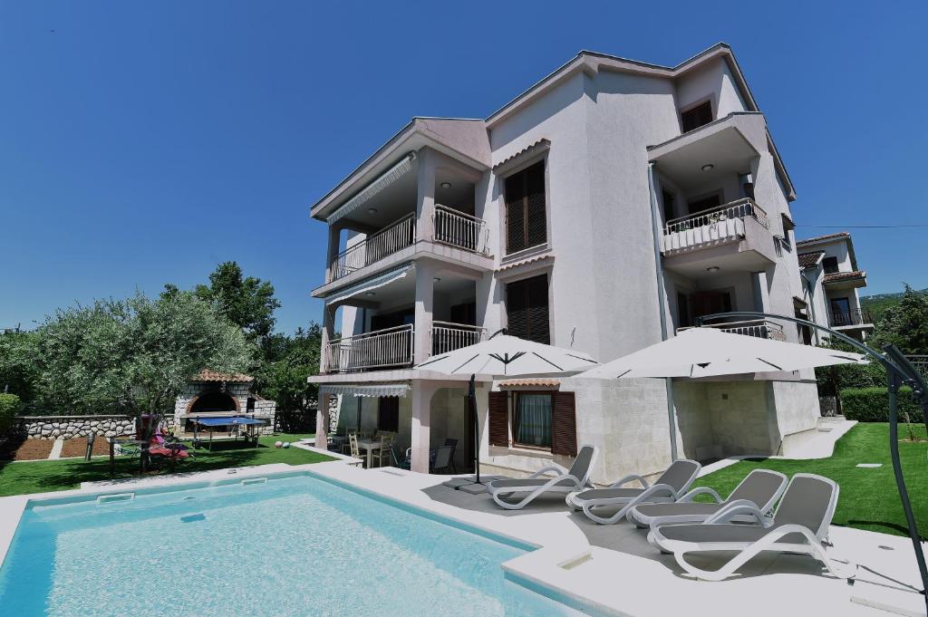 a villa with a swimming pool and chairs at Villa Maravilla in Jadranovo
