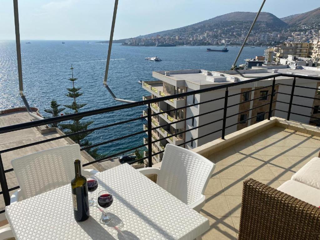 a bottle of wine sitting on a table on a balcony at Seaside Escape in Polisi i Vogël