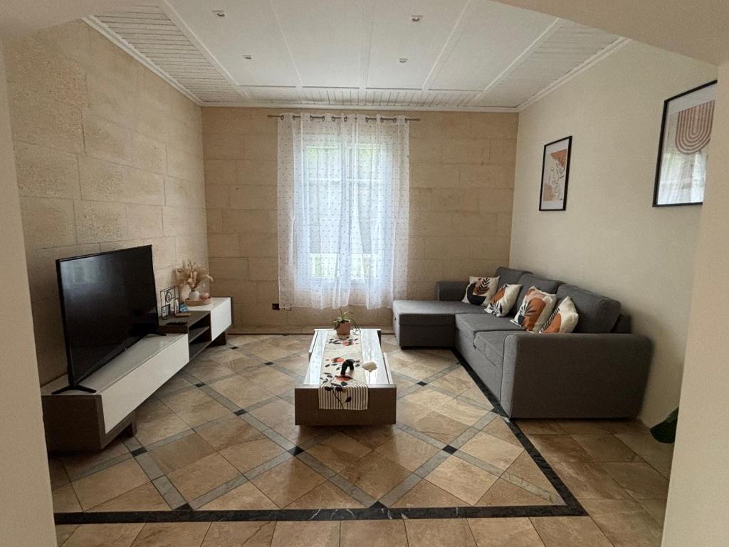 un salon avec un canapé et une télévision dans l'établissement Maison Colibri, à Salies-de-Béarn