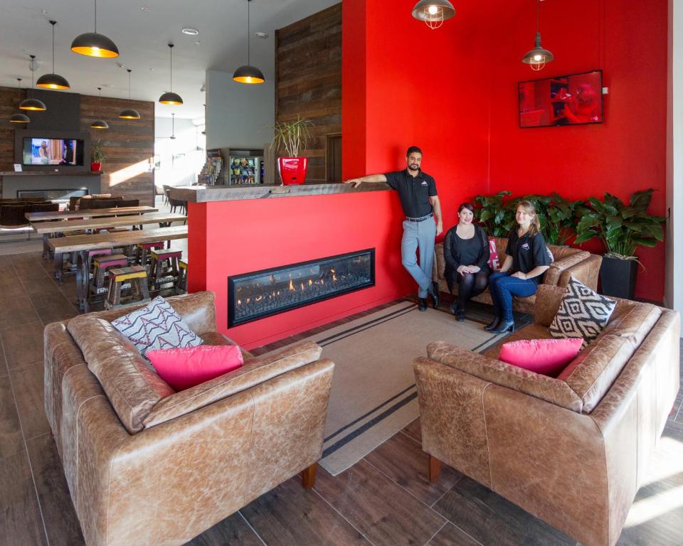 a man standing next to a fireplace in a living room at Urbanz in Christchurch