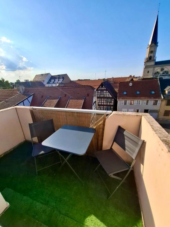 a table and two chairs on a roof at Au Nichoir in Erstein