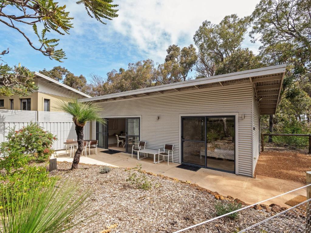 a white house with a patio in a yard at Wren Studio - Private One-Bedroom Studio Nestled in Bushland in Yallingup