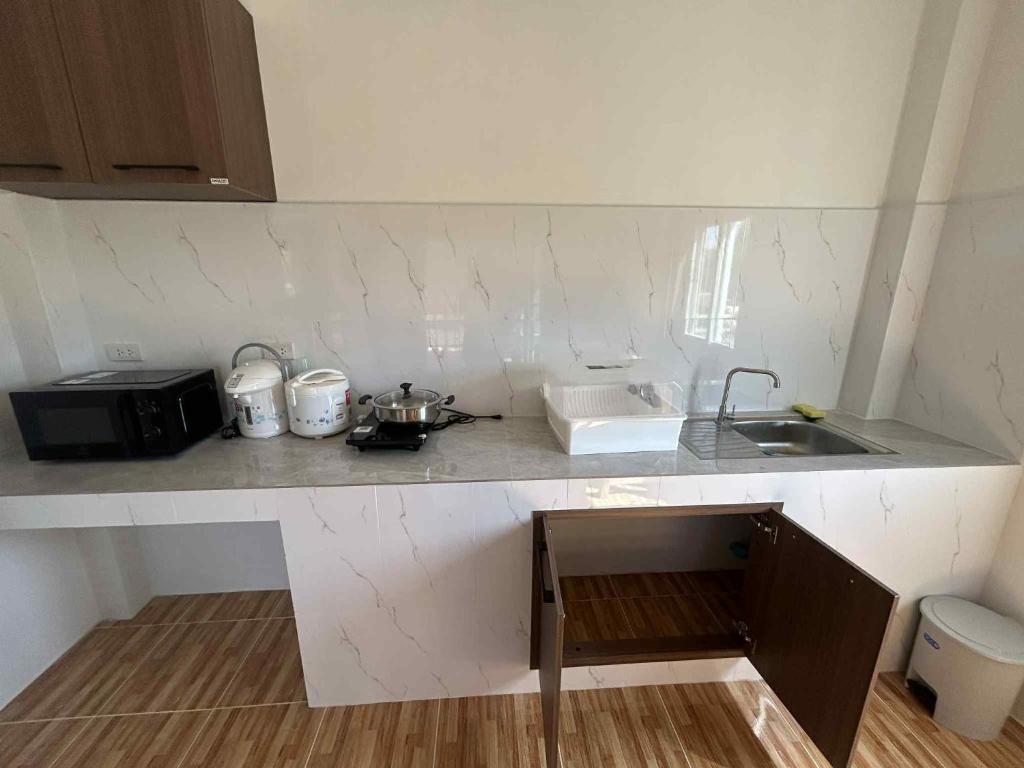 een keuken met een spoelbak en een aanrechtblad bij Wimanthara houses in Thongsala