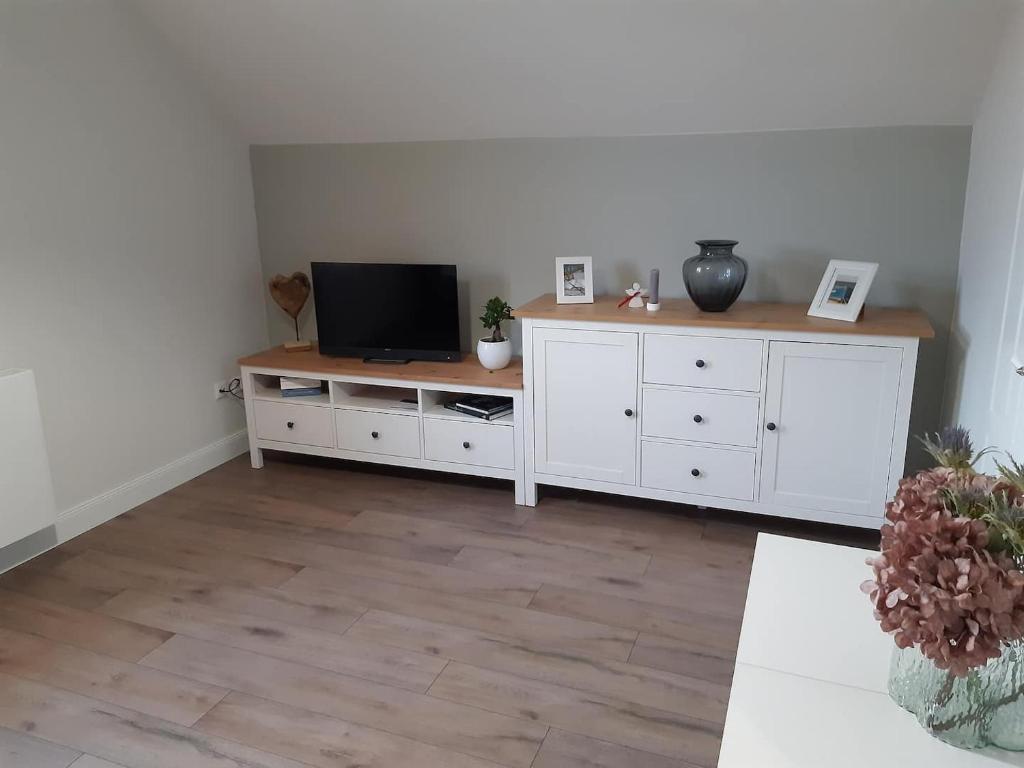 a living room with a television on a white cabinet at Gesamte Unterkunft Apartment in Ludwigslust in Ludwigslust