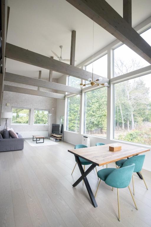 a living room with a wooden table and blue chairs at Grey House Niseko in Niseko