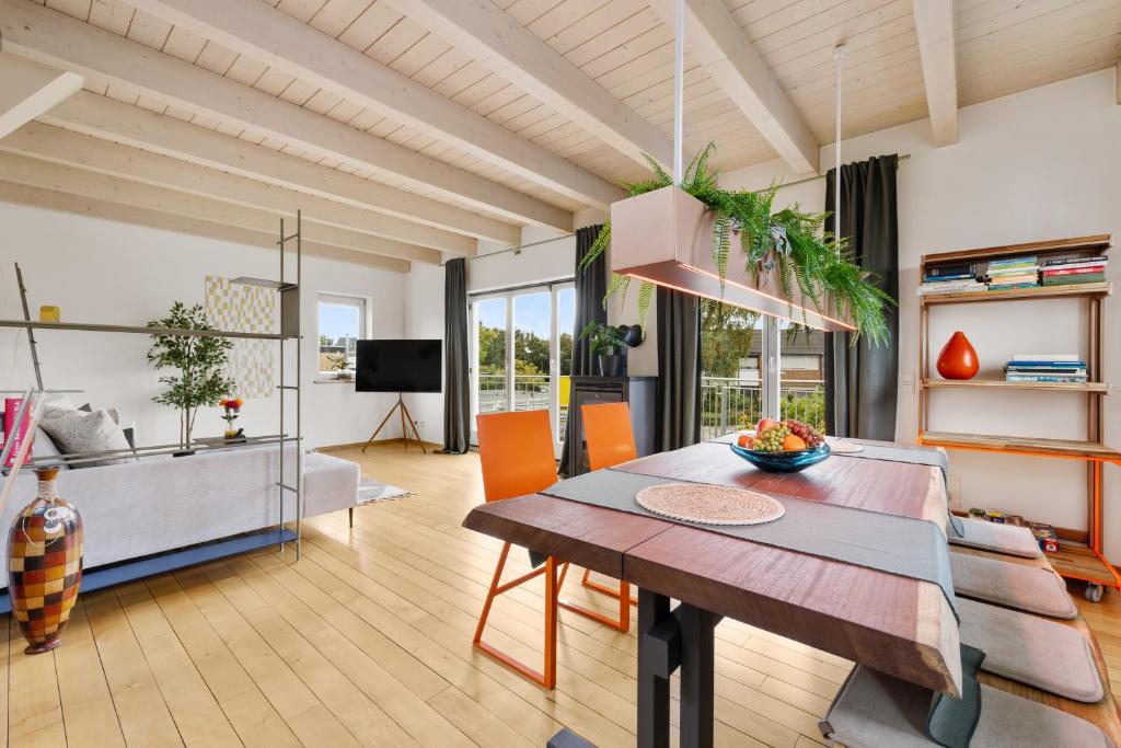 a living room with a table and a dining room at Svyvo Cologne-Esch Design Apartment in Cologne