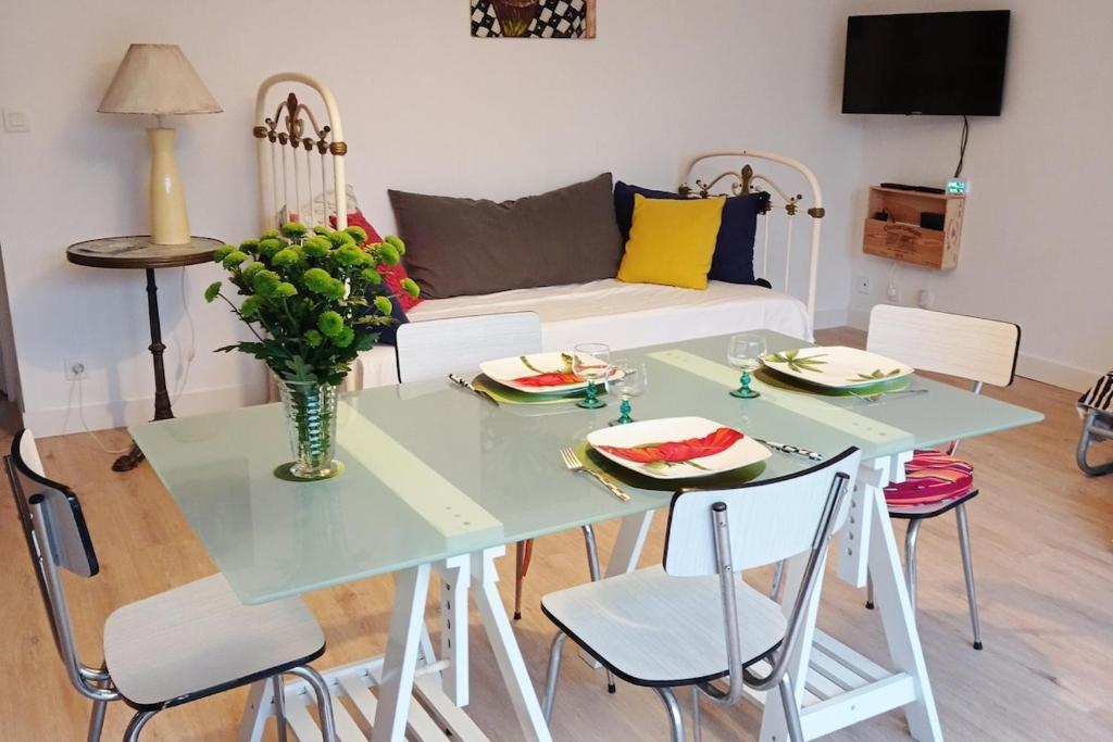 a living room with a table and a couch at une terrasse en ville in Langon