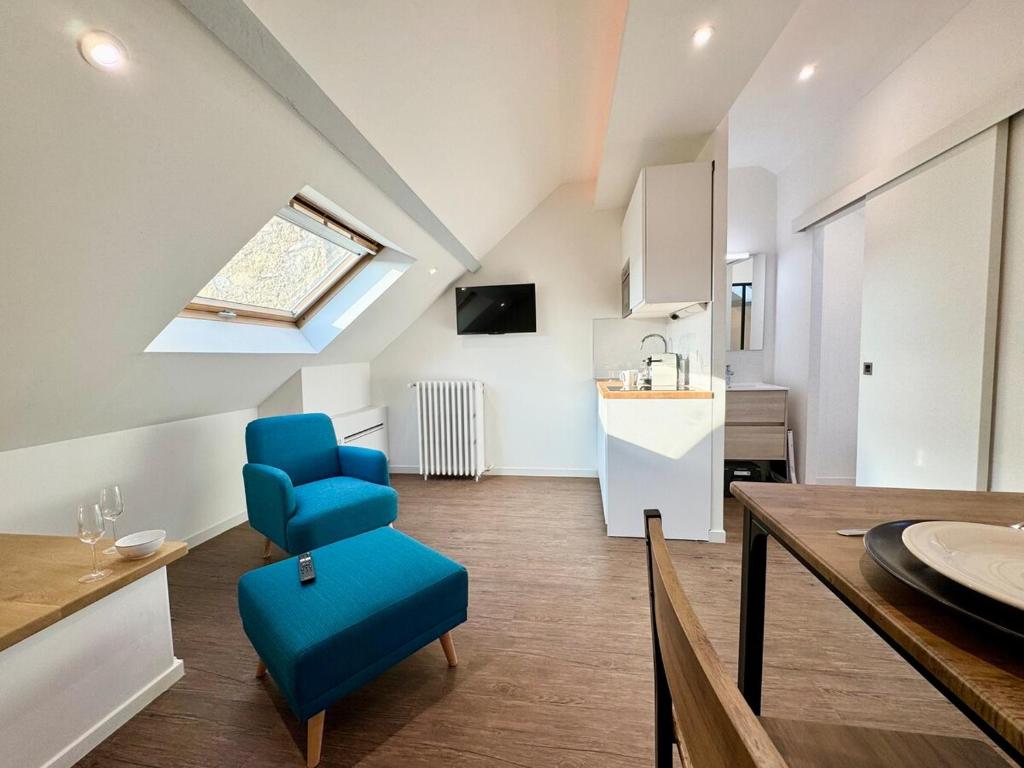 a living room with a blue chair and a kitchen at Wellness Suite Ponsardin 3 - Reims Centre in Reims