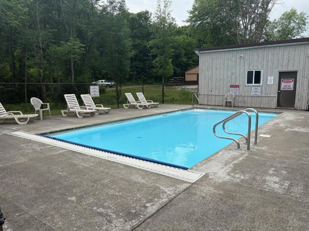 a large blue swimming pool with chairs and a building at Cliffside Hideaway-Renovations & upgrades coming! in Hammond