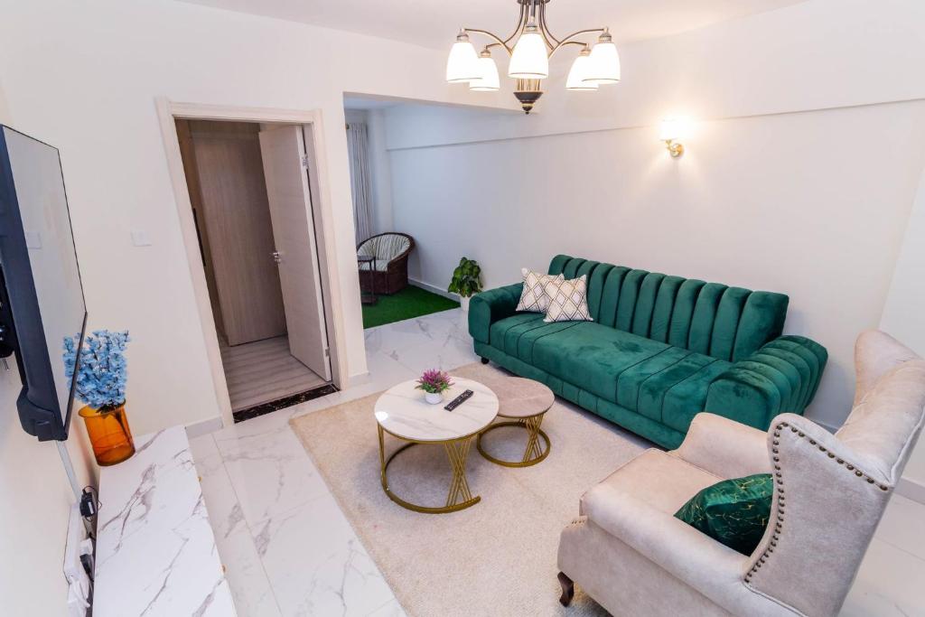 a living room with a green couch and a table at Luxurious Nairobi Apartment with City and Garden Views in Nairobi