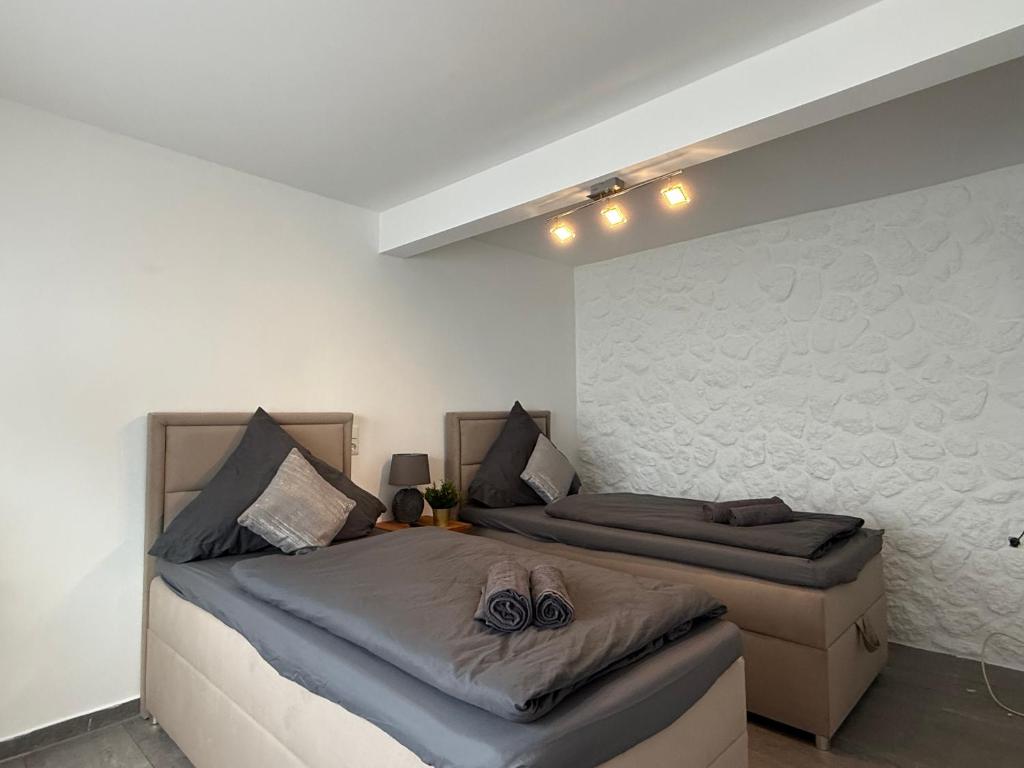 a bedroom with two beds and a wall at Apartment Mira 12 in Pulheim