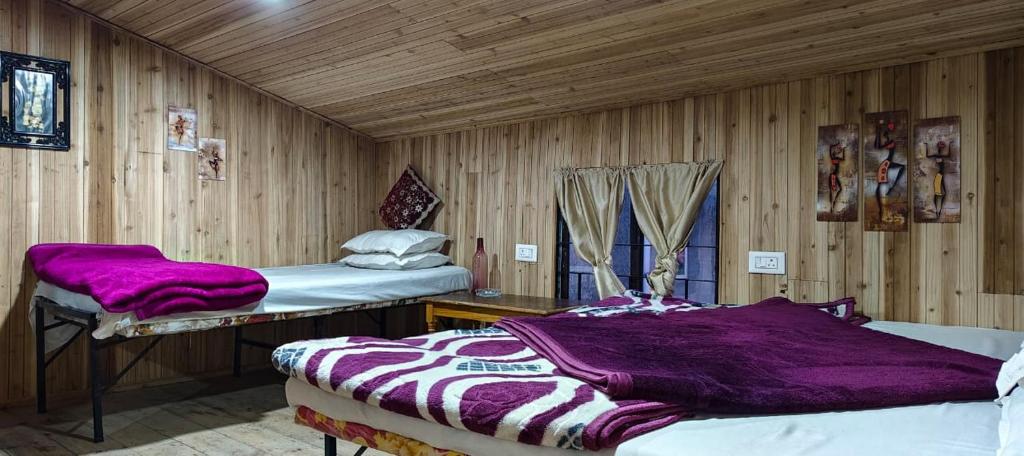 大吉岭Shubh Aagaman Homestay的一间木墙房间里有两张床