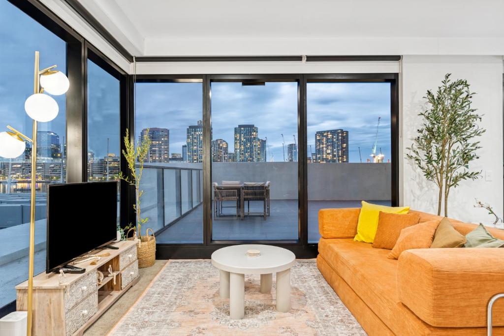 ein Wohnzimmer mit Sofa und Fernseher in der Unterkunft Luxury Marina Tower Stay Waterfront & City Views in Melbourne