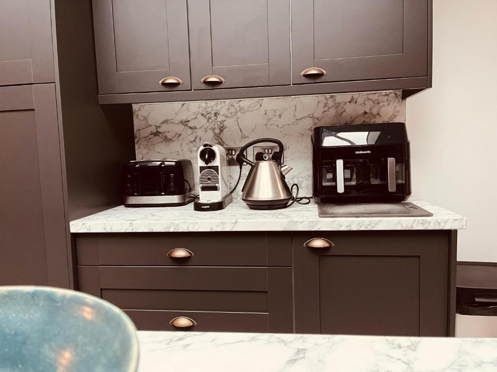 eine Küchentheke mit Kaffeemaschine und Toaster in der Unterkunft Stylish & Spacious Victorian Home near Severn Valley Railway & Safari Park in Kidderminster